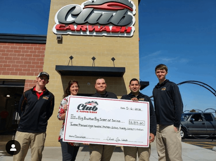 salina locations weekend fundraiser check presentation in front of car wash building